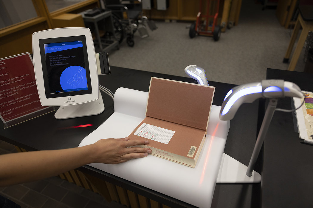 table with iPad and scanner to self-checkout books